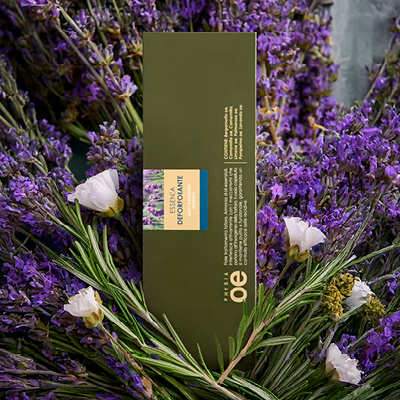 immagine del prodotto fiala essenza ambientata su sfondo con lavanda, rosmarino e fiori bianchi